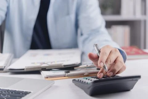Close up of business man hand using calculator to calculate financial repor.. Stock Photos
