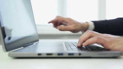 Close up of a business man typing on a silver laptop. Stock Footage 72143778
