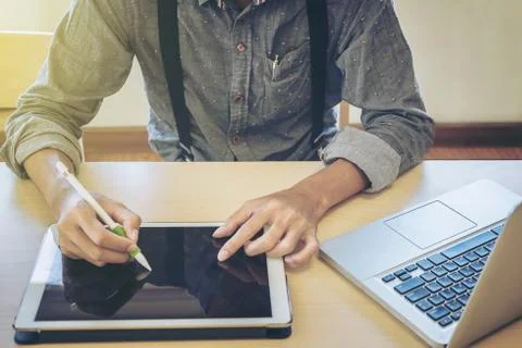Close-up of business man using tablet and computer to working financial data. Stock Photos