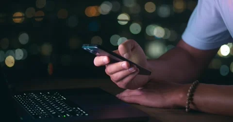 Close-up of business man writing a message on a mobile phone while working on a Stock Footage 244190107