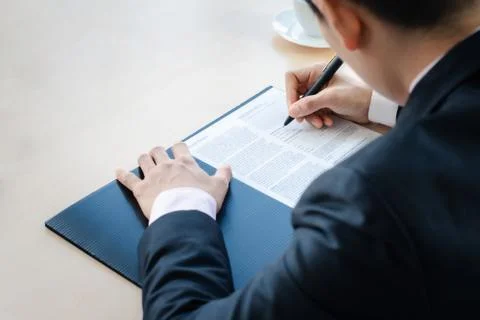 Close up business man writing or signing contract on paper in office.. Foto stock