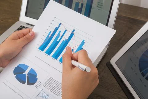 Close-up of business person using digital tablet and laptop with financial .. Stock Photos