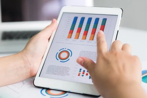 Close-up of business person using digital tablet with financial diagram Stock Photos