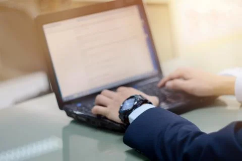 Close up of business person's hands using laptop on table in the office. Clos Stock Photos