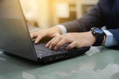 Close up of business person's hands using laptop on table in the office. Clos Stock Photos