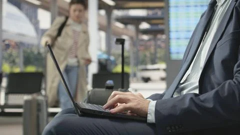 Close up of business professional typing on notebook in public transit hub Stock Photos