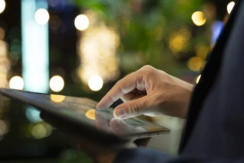 Close up of business professional using tablet touchscreen at night 스톡 사진