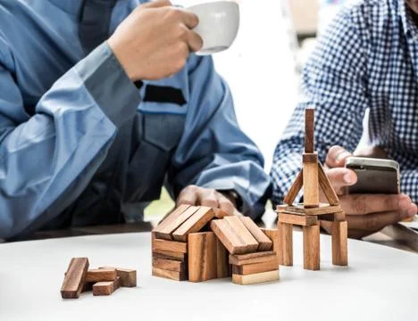 Close Up of business team making a structure with wooden cubes. Building a bu Stock Photos