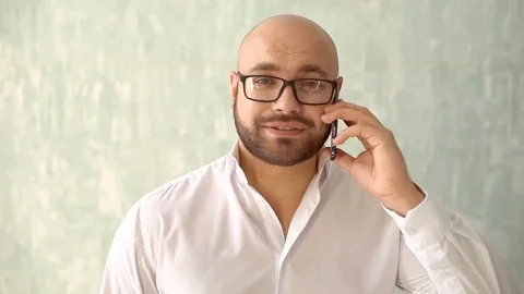 Close up of businessman bearded face talking on mobile phone. A Stylish man in a Stock Footage 86790412
