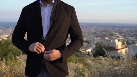 Close-up of businessman buttoning blazer against city skyline Stock Footage 133375161