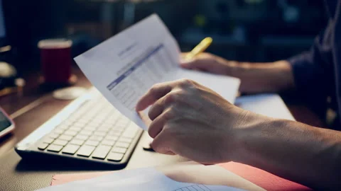 Close-up of a businessman checking financial data on clipboard documents an.. Video stock 345942132