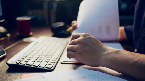Close-up of a businessman checking financial data on clipboard documents an.. Video stock 345942154