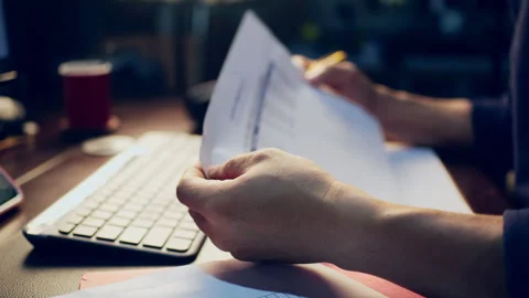 Close-up of a businessman checking financial data on clipboard documents an.. Video stock 345942197