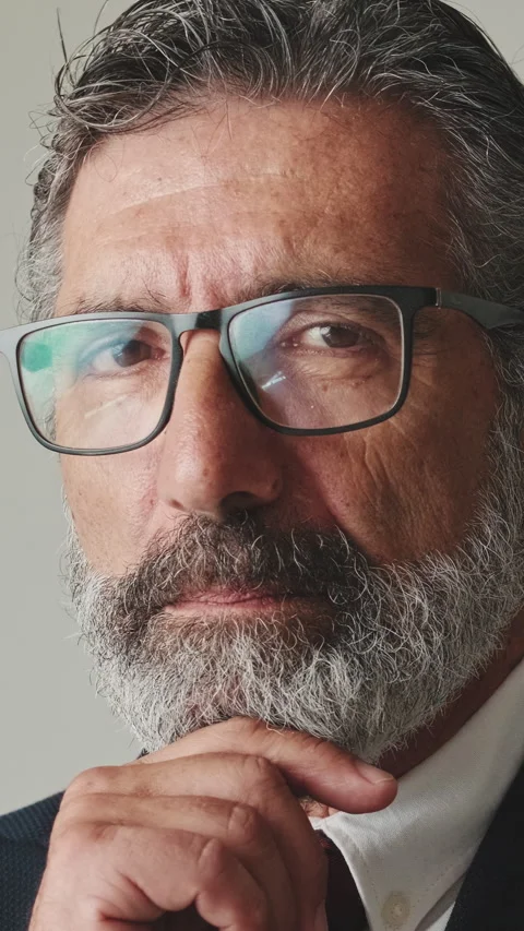 Close up, businessman hand props chin turns his head and looks at the camera, on Stock Footage 252503053