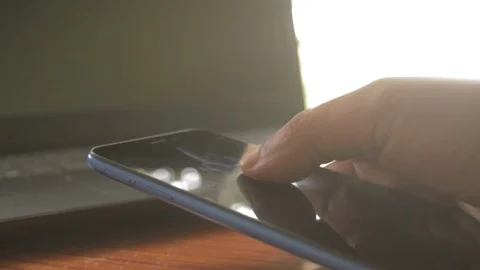 Close up businessman hand using mobile phone. Out of focus laptop device scre Stock Footage 129212000