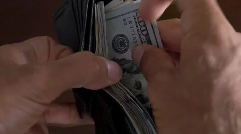 Close-up of a businessman hands counting hundred dollar bills in wallet Stock Footage 66654384