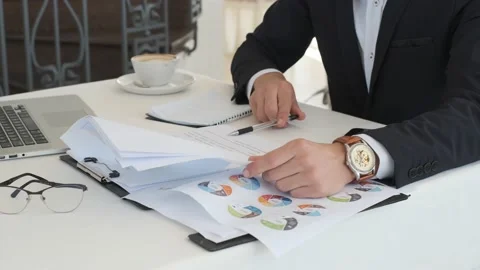 Close up. Businessman looks through documents and writes information to notepad Stock Footage 130914403
