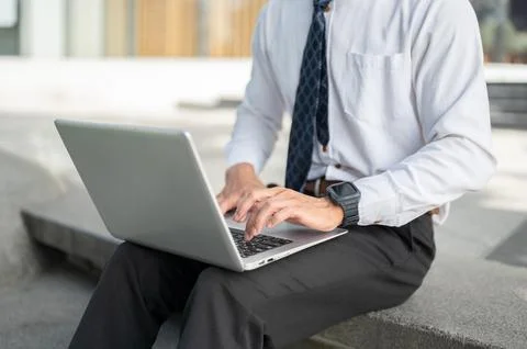 Close up of businessman office worker using laptop outdoors, highlighting r.. Foto stock