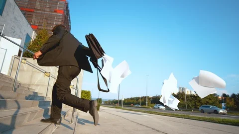CLOSE UP: Businessman running late to work and losing important paperwork. Stock Footage 101331180