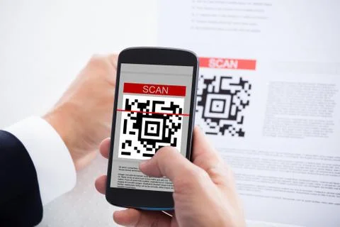 Close-up of businessman scanning a barcode using cell phone Stock Photos