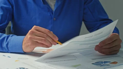 Close-up businessman takes notes in documents, graphs and works behind a laptop Stock Footage 170358979