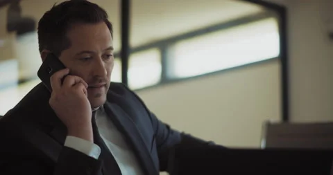 Close up of a businessman talking on the phone while working from his office. Stock Footage 140206376