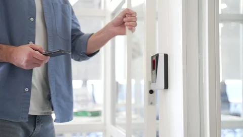 Close up of businessman unlocking door using mobile phone application. Unlocks  Stock Footage 305694315