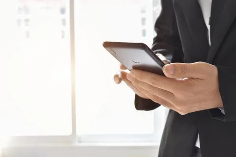 Close up of businessman using a cell phone. Young business executive with mob Stock-Fotos