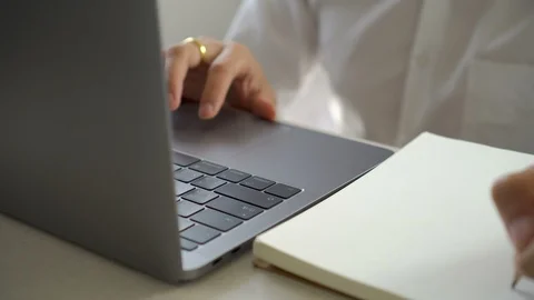 Close up businessman using laptop and writing notes on notebook. Video stock 93673906