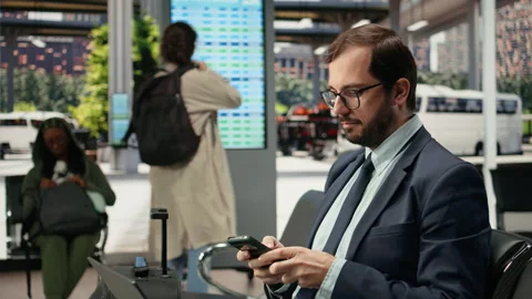 Close up of businessman using mobile phone in bus station Stock Footage 341971416