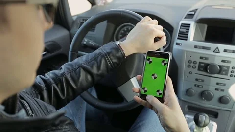 Close-up of a businessman using a smartphone with mock-up green screen in a car. Stock Footage