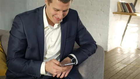 Close up businessman using smartphone while sitting on couch Stock Footage 107943770
