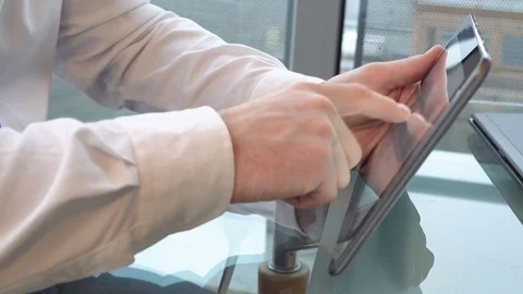 Close up on businessman's hands browsing tablet computer, on table, office Stock Footage