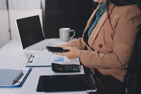 Close-up of businessman's hands making notes, mobiles, chart, desk, office Stock Photos