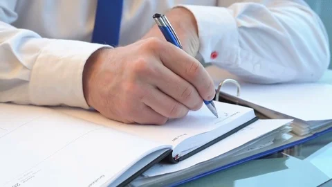 Close up on businessman's hands writing notes in calendar  Vídeos de archivo 73422045