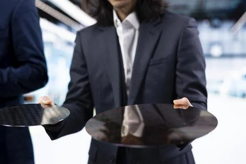 Close up of businessmen comparing semiconductor substrates Stock Photos