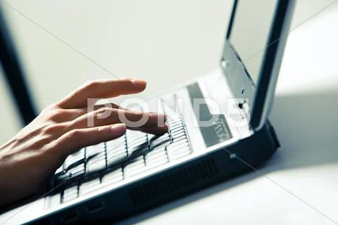 Close-up of businesswomans fingers pushing keys of laptop on desk Stock Photos