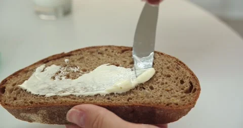 Close-up of butter is spread on bread Видео 155320418