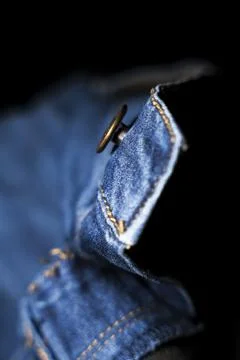 Close-Up of Button on Blue Jeans, Isolated on Black Background Stock Photos