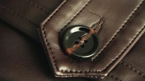 A close-up of a button on a leather item, highlighting the texture and detail of Stock Footage 334944113