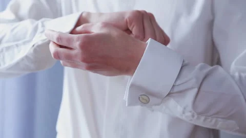 Close up of buttons, clasps. The man fastens a button, cufflinks on a white Stock Footage 170391343