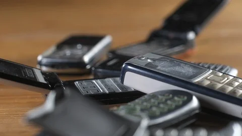 Close-up of buttons on the keyboard of a pile of old mobile phones. Stock Footage 128095755