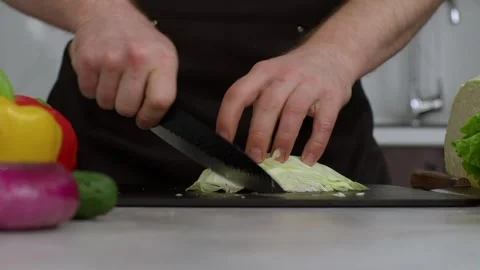 Close-up of a cabbage on the kitchen table. The cook cuts the cabbage. With Vidéo 269112871