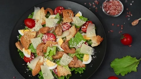 Close-up of a Caesar Salad in a black plate against a Black Background Stock Footage 237703476