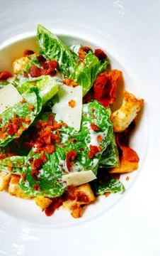 Close up of Caesar salad with cheese, bread, fried bacon and fresh vegetable Stock Photos