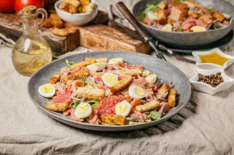 Close-up Caesar salad with red fish, romaine lettuce, quail eggs, garlic crou Stock Photos