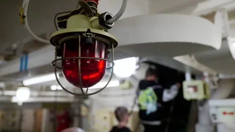 Close-up of a caged red warning beacon mounted to the ceiling in an industrial Stock Footage 318292654