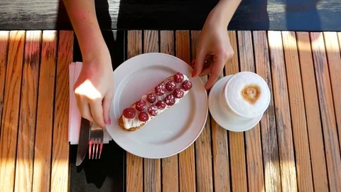Close up of cake with raspberry sauce on plate, cup of cappuccino in coffee shop Video stock 100035262
