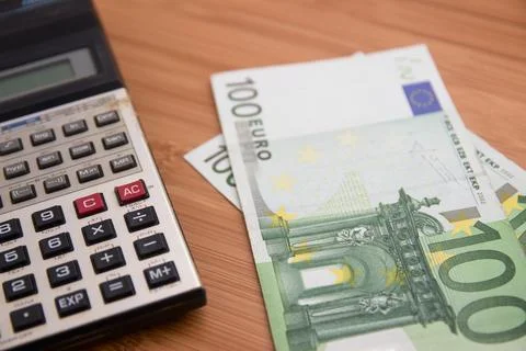 Close-up of a calculator next to some 100 euro bills Stock Photos