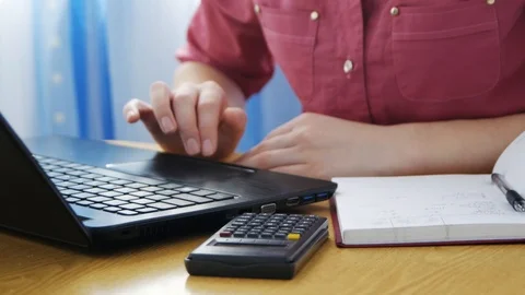 Close up calculator on table, female hands typing on laptop, student writing  Vídeo Stock 107184539